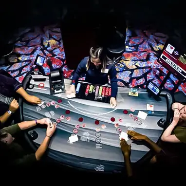 A shot from above of a Quil Ceda Creek table games table with a dealer and four players. gaming options